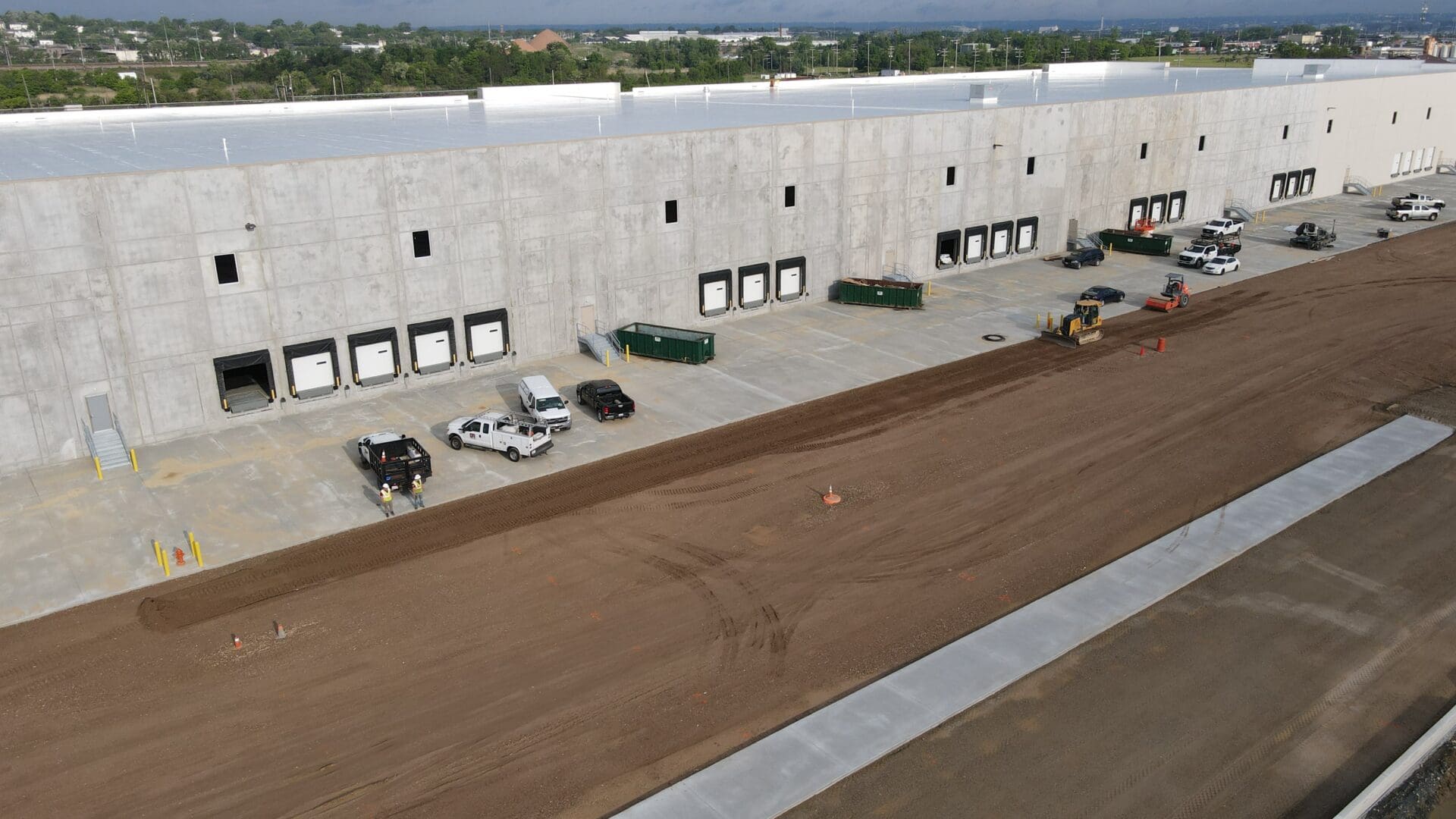 A large warehouse with cars parked on the side of it.